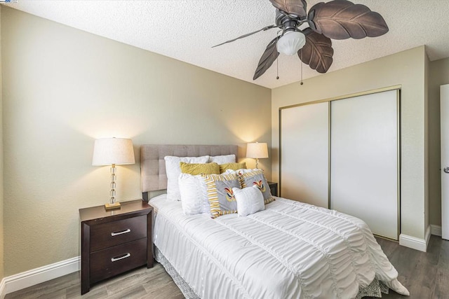 bedroom with hardwood / wood-style flooring, ceiling fan, a closet, and a textured ceiling