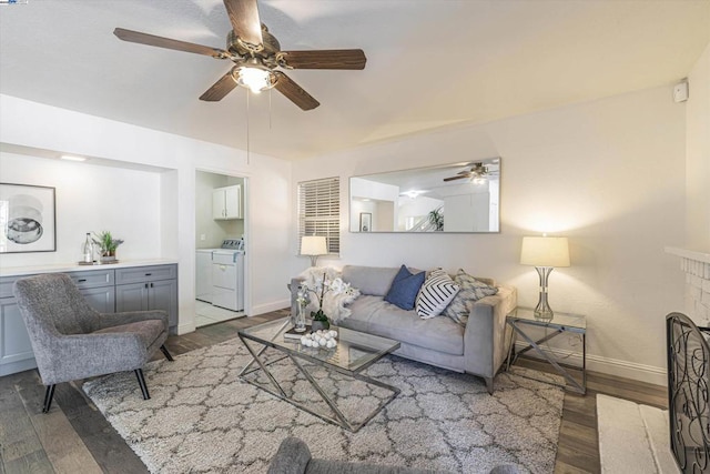 living room with a fireplace, independent washer and dryer, ceiling fan, and light wood-type flooring