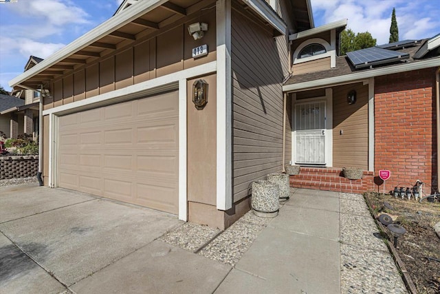 property entrance featuring a garage and solar panels