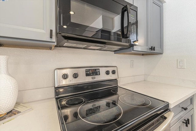 kitchen featuring stainless steel electric range and gray cabinets