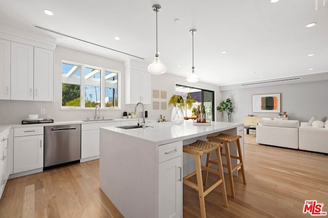 kitchen featuring a kitchen island with sink, sink, stainless steel dishwasher, and white cabinets