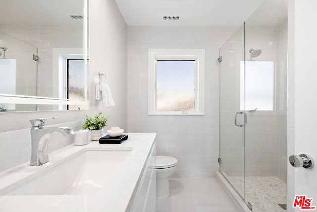 bathroom featuring walk in shower, vanity, toilet, and plenty of natural light