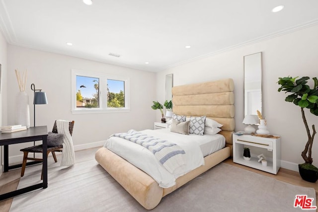 bedroom with ornamental molding and light wood-type flooring