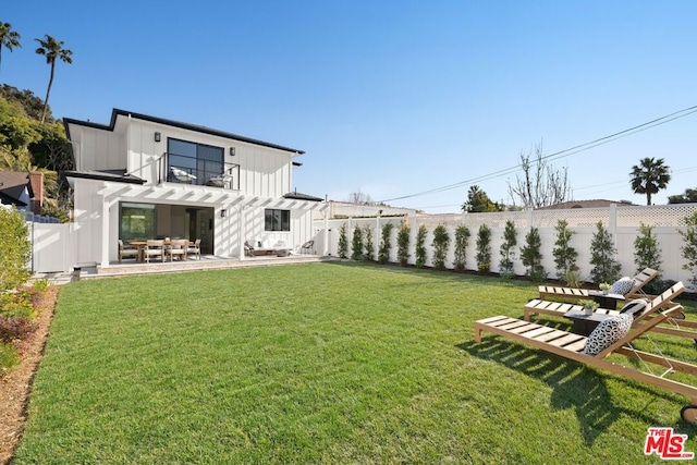 back of house featuring a balcony, a yard, and a patio