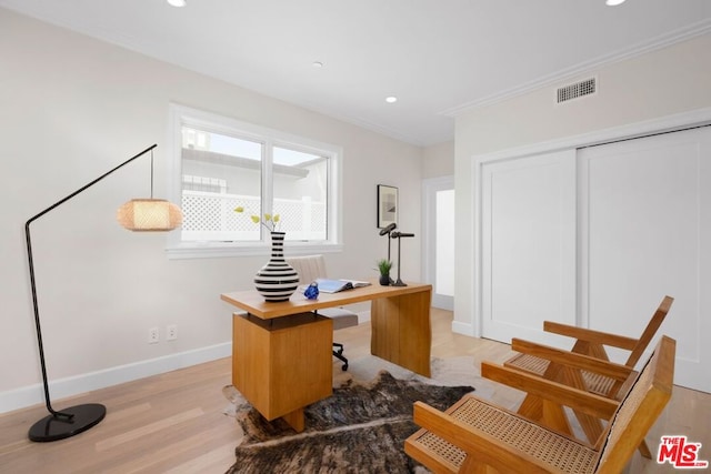 office space with crown molding and light hardwood / wood-style flooring