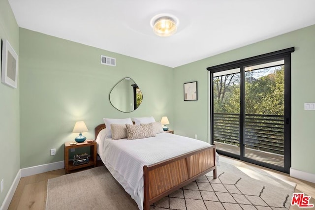 bedroom with access to outside and light wood-type flooring