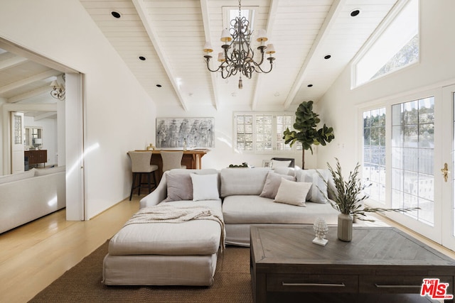 living room featuring an inviting chandelier, hardwood / wood-style floors, and lofted ceiling with beams