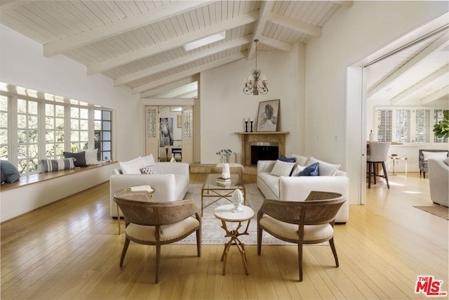 living room featuring beamed ceiling, high vaulted ceiling, light hardwood / wood-style floors, and a notable chandelier