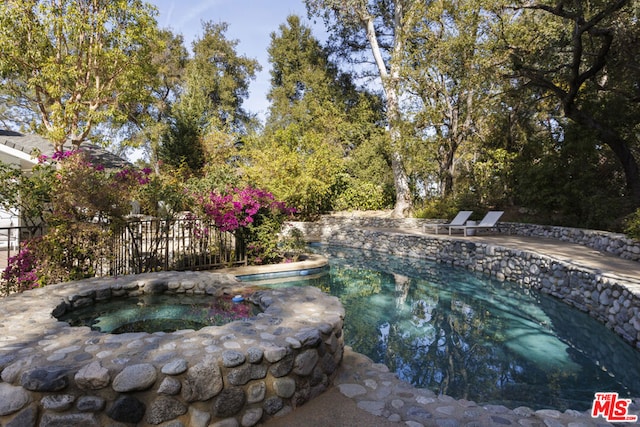 view of swimming pool with a patio and an in ground hot tub