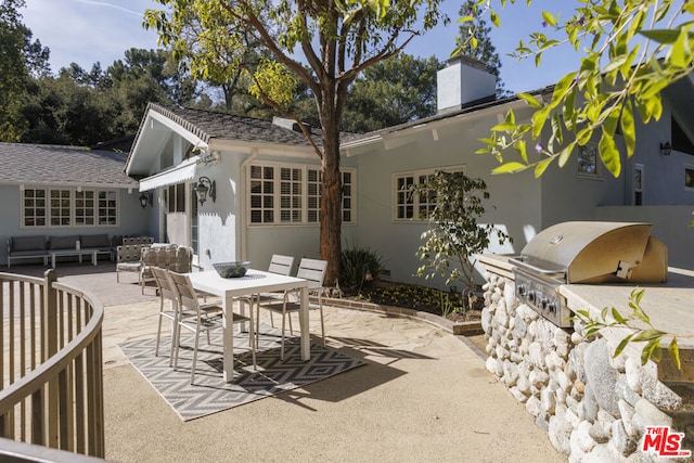 rear view of house featuring an outdoor hangout area, a patio, and exterior kitchen