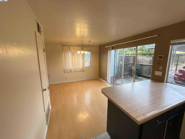 kitchen with an inviting chandelier, hanging light fixtures, and light hardwood / wood-style floors