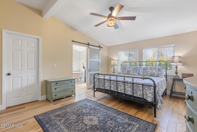 bedroom featuring vaulted ceiling with beams, ensuite bath, light hardwood / wood-style flooring, ceiling fan, and a barn door