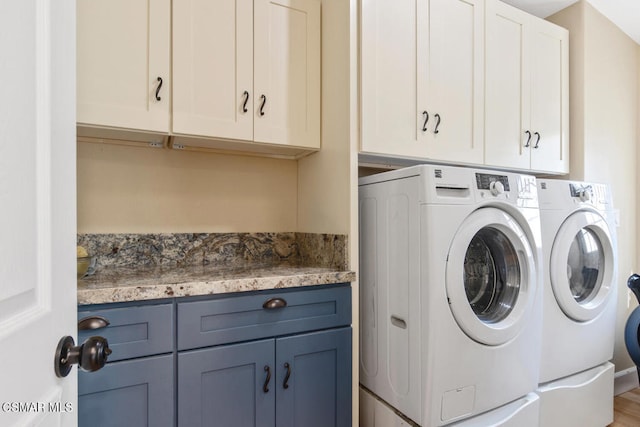 washroom featuring cabinets and separate washer and dryer