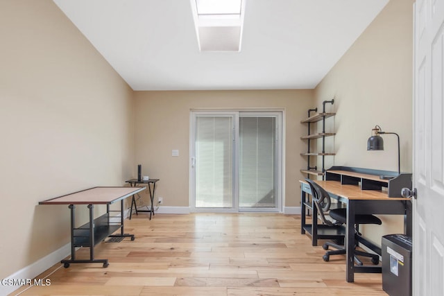 office area featuring light wood-type flooring and a skylight