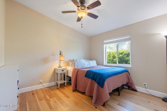 bedroom with ceiling fan, lofted ceiling, and light wood-type flooring