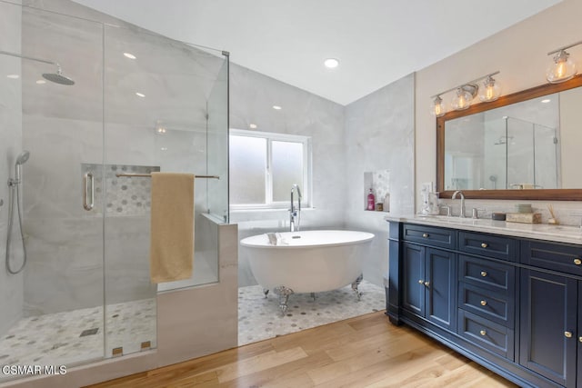 bathroom with vanity, hardwood / wood-style flooring, lofted ceiling, and plus walk in shower