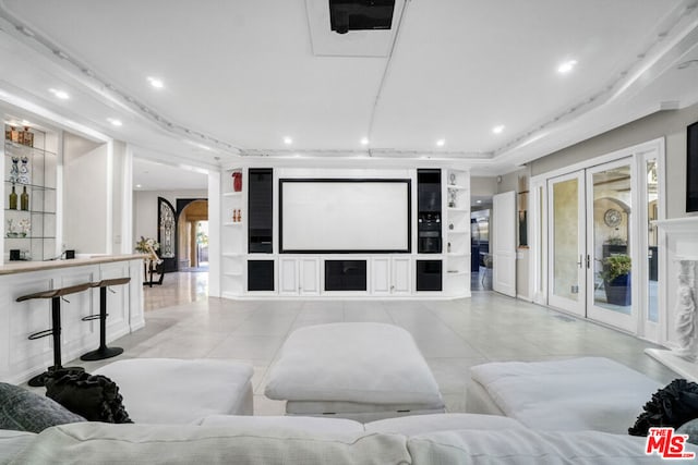 home theater featuring light tile patterned floors, built in shelves, and french doors