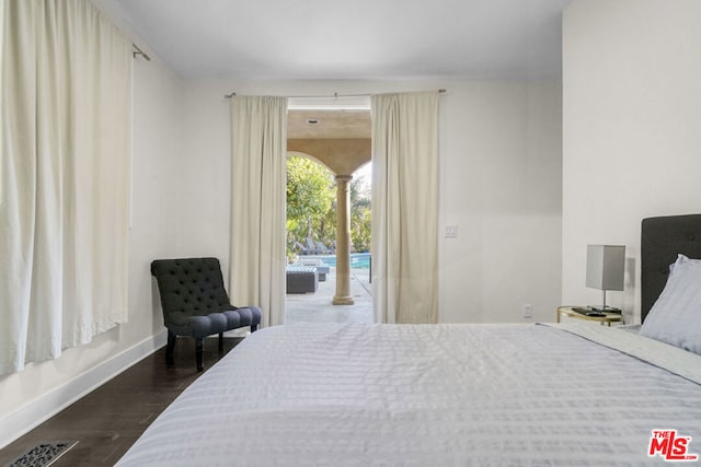 bedroom with dark wood-type flooring and access to outside