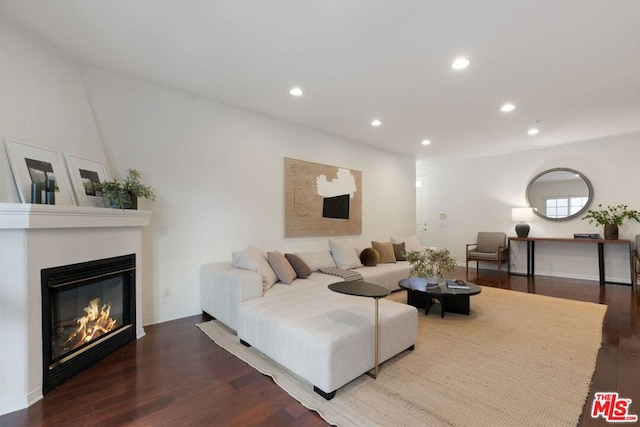 living room with dark hardwood / wood-style flooring and a fireplace