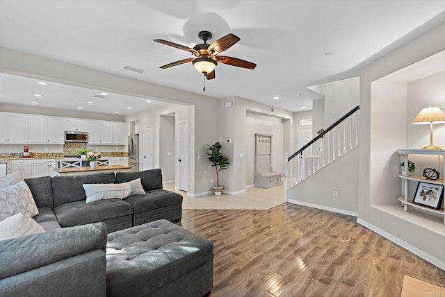 living room with ceiling fan and light hardwood / wood-style flooring