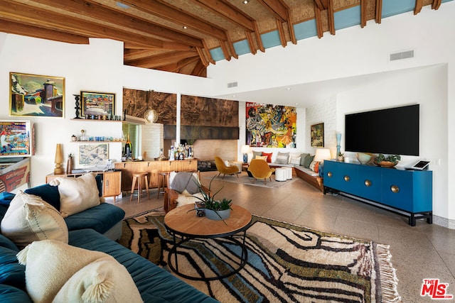 living room with beam ceiling and a high ceiling