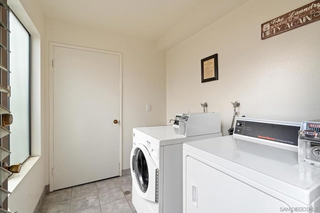 laundry room featuring washing machine and dryer and light tile patterned floors