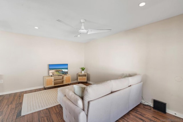 living room featuring dark wood-type flooring and ceiling fan