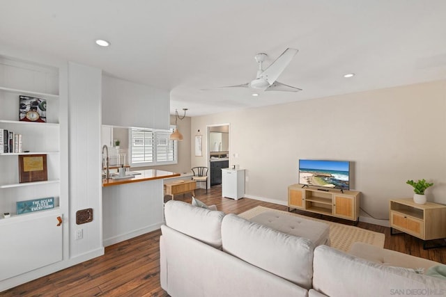 living room with ceiling fan and dark hardwood / wood-style flooring