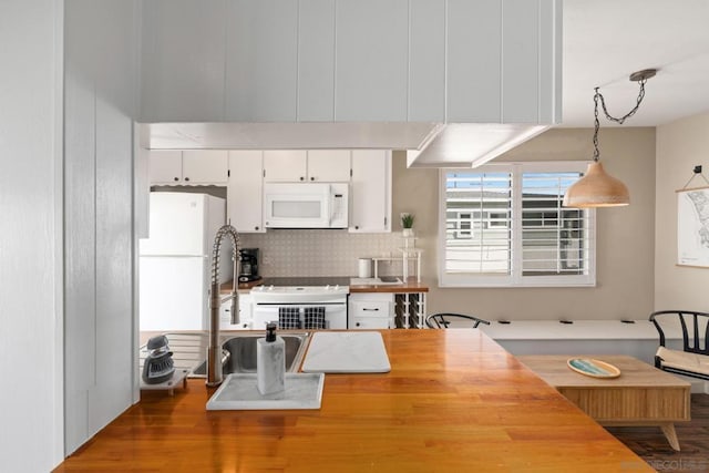 kitchen with sink, white cabinetry, tasteful backsplash, range, and hanging light fixtures