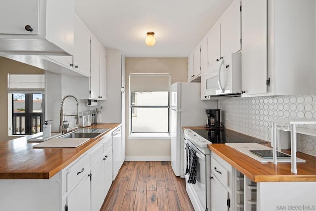 kitchen with sink, white appliances, white cabinets, and backsplash