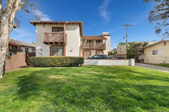 back of property with a balcony and a lawn