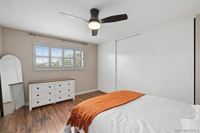 bedroom with dark hardwood / wood-style flooring, a closet, and ceiling fan