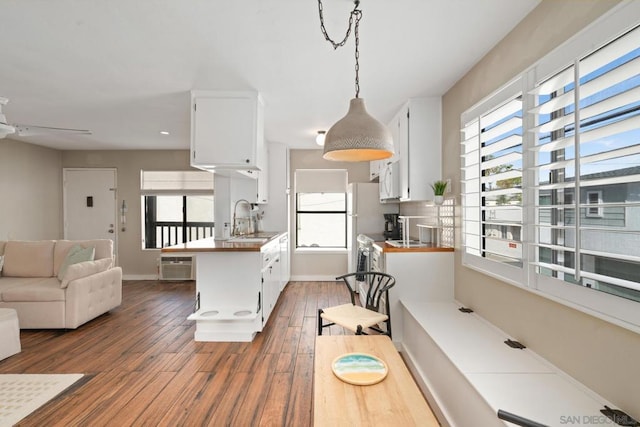 kitchen with white cabinetry, sink, decorative light fixtures, and dark hardwood / wood-style floors