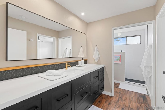 bathroom featuring vanity, wood-type flooring, and tiled shower