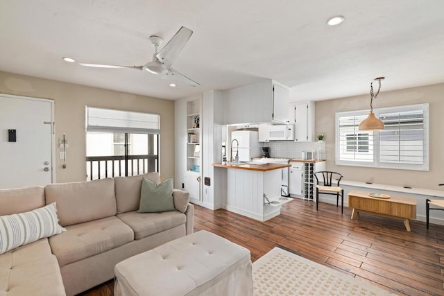 living room with ceiling fan, hardwood / wood-style flooring, sink, and a healthy amount of sunlight