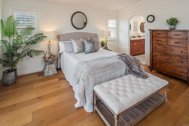 bedroom featuring ensuite bathroom and light hardwood / wood-style floors