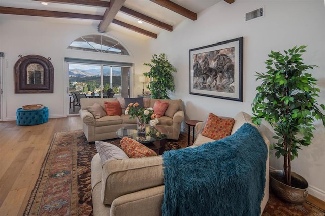 living room with vaulted ceiling with beams and hardwood / wood-style flooring