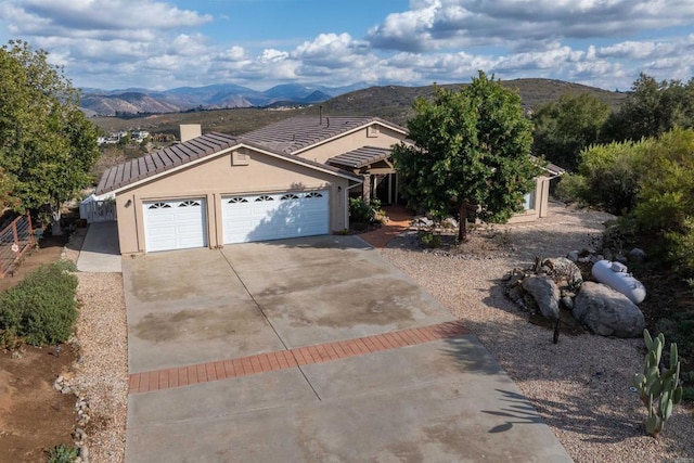 single story home with a garage and a mountain view