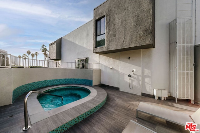 view of swimming pool featuring a hot tub