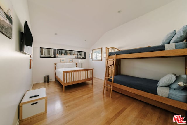 bedroom featuring lofted ceiling and light hardwood / wood-style flooring