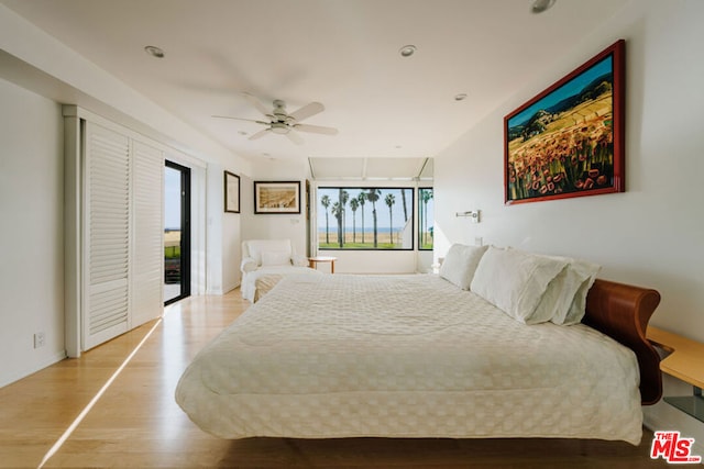 bedroom with light hardwood / wood-style flooring, ceiling fan, and access to outside