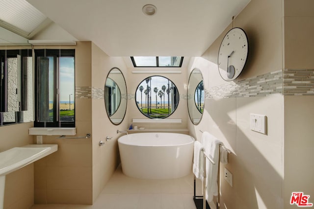 bathroom with tile patterned floors and a tub to relax in