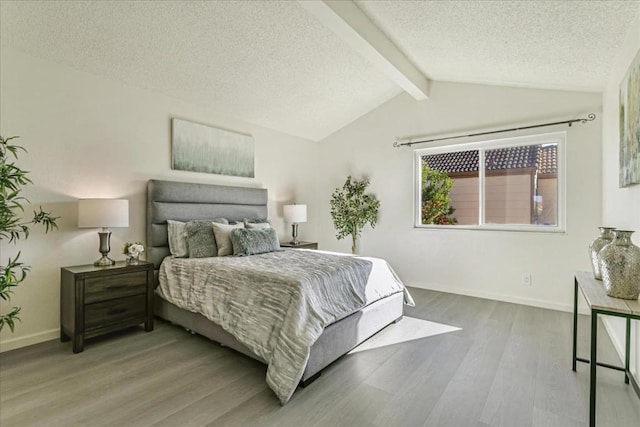 bedroom with lofted ceiling with beams, hardwood / wood-style floors, and a textured ceiling