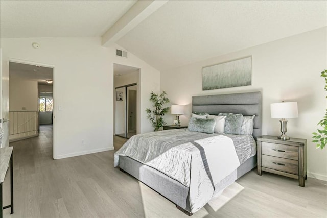 bedroom featuring vaulted ceiling with beams and light hardwood / wood-style floors