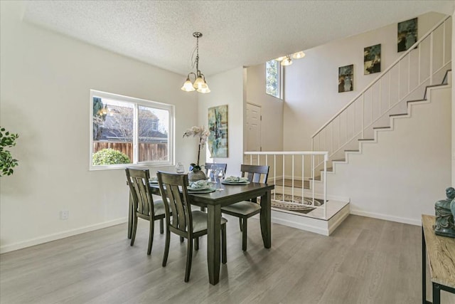 dining space featuring hardwood / wood-style floors, a chandelier, and a textured ceiling