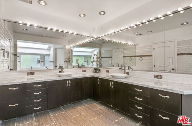 bathroom featuring vanity and backsplash