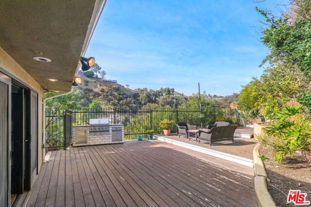 deck with area for grilling, a mountain view, and outdoor lounge area