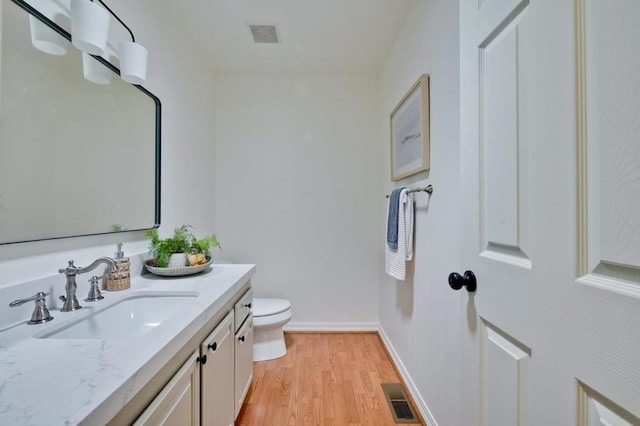 bathroom featuring vanity, wood-type flooring, and toilet