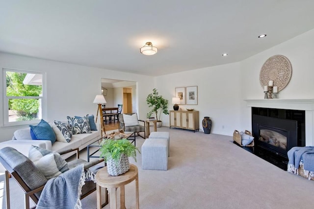 living room featuring light colored carpet and a tiled fireplace