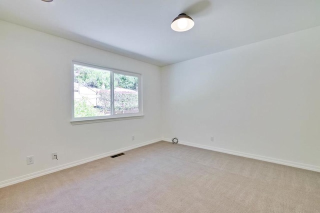 spare room featuring light colored carpet